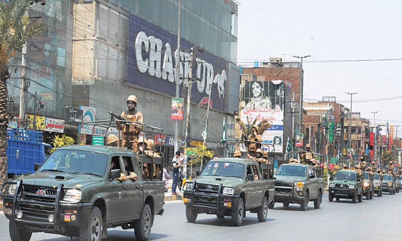 FAISALABAD: Army vehicles patrol Satyana Road to maintain law and order, on Friday.—Online