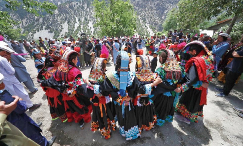 Women in colourful clothes present a traditional dance during Chilim Jusht festival in Kalash valley, Chitral, on Monday. &mdash; Dawn