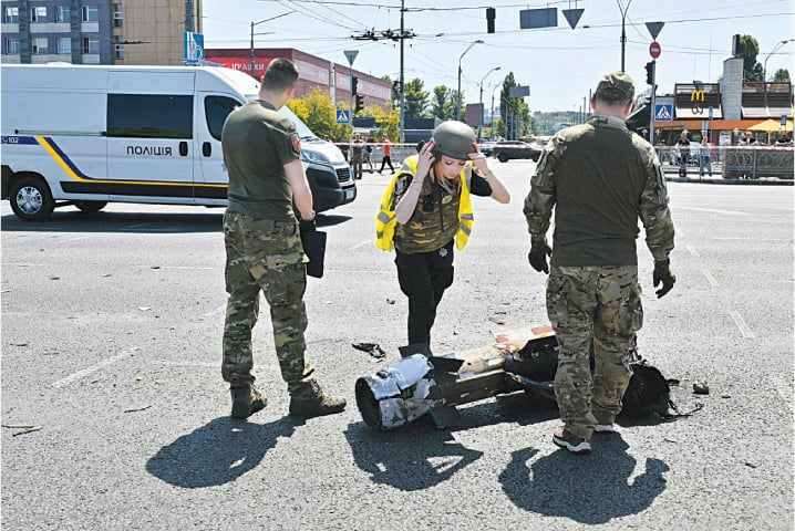 Police experts examine fragments of a missile after Russia fired a barrage of missiles in Kyiv, on Monday.—AFP