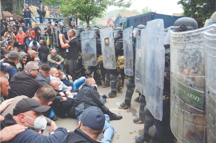  Serbs from Kosovo face riot police during their gathering in Zvecan town to demand the removal of recently elected Albanian mayors, on Tuesday.&mdash;AFP 