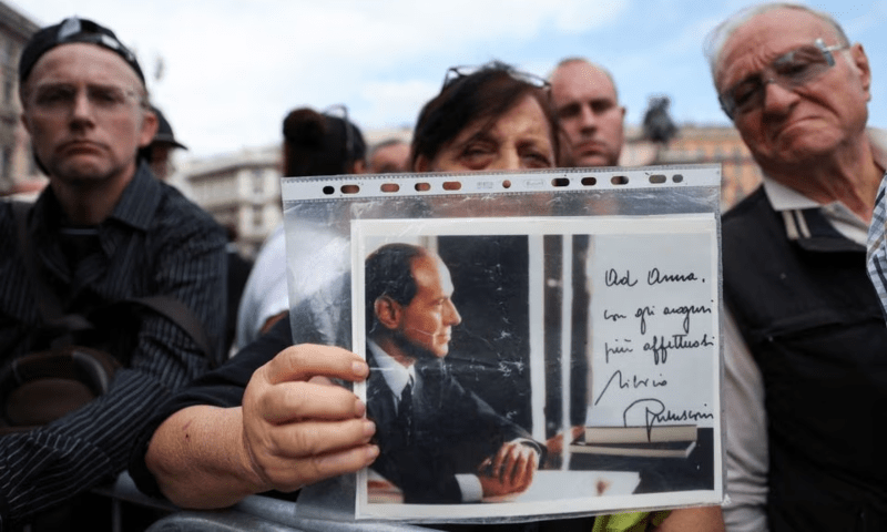 A person holds a picture of former Italian Prime Minister Silvio Berlusconi on the day of his funeral, in Milan, Italy on June 14.  &mdash;  Reuters