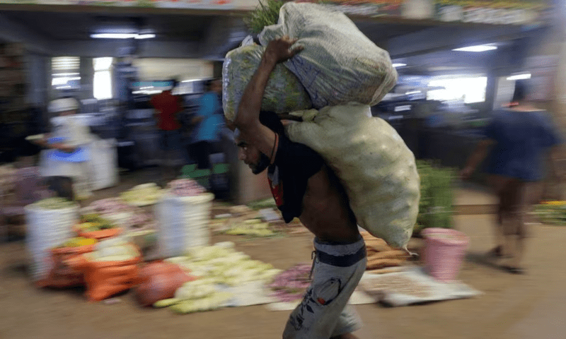 A worker carries sacks of vegetables at a wholesale market, as Sri Lanka’s key inflation rate eases to 25.2% in May, in Colombo, Sri Lanka on June 1. — Reuters A worker carries sacks of vegetables at a wholesale market, as Sri Lanka’s key inflation rate eases to 25.2% in May, in Colombo, Sri Lanka on June 1. — Reuters