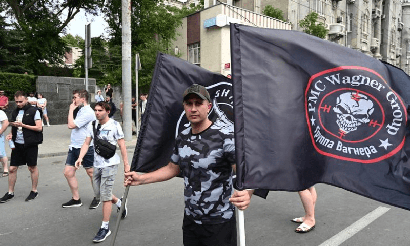 A supporter of Wagner private mercenary group holds flags near the headquarters of the Southern Military District controlled by Wagner fighters in the city of Rostov-on-Don, Russia on June 24. — Reuters