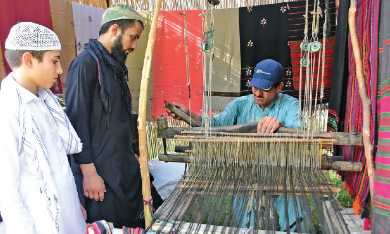 An artisan weaves khadi on a handloom at the ongoing Saqafati Mela at Lok Virsa on Saturday. &mdash; Online