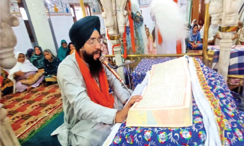 A pilgrim recites Guru Granth Sahib at the Gurdwara Punja Sahib in Hassanabdal on Sunday. &mdash; Dawn