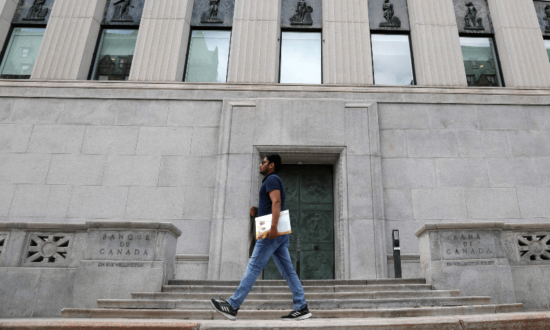 A pedestrian walks past the Bank of Canada in Ottawa, Ontario, Canada, on July 12. &mdash; AFP