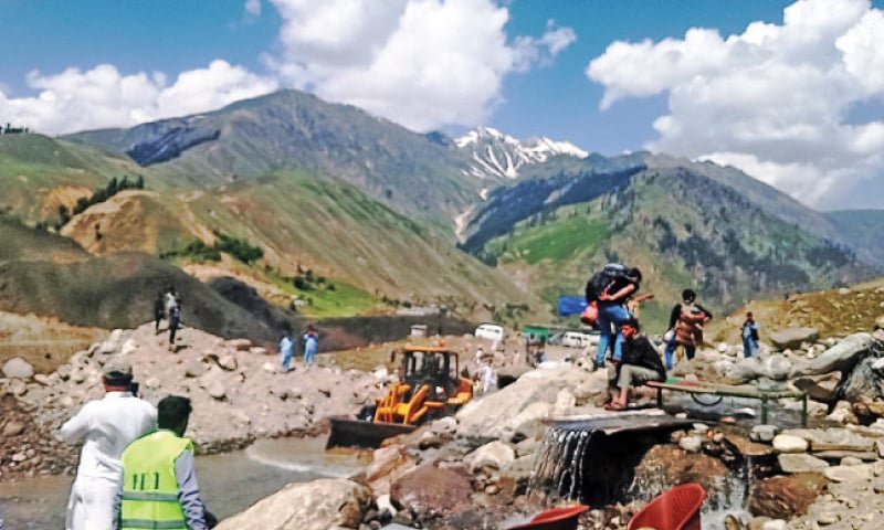 A machine clears a road in Soach area of Kaghan valley on Saturday. &mdash; Dawn photo