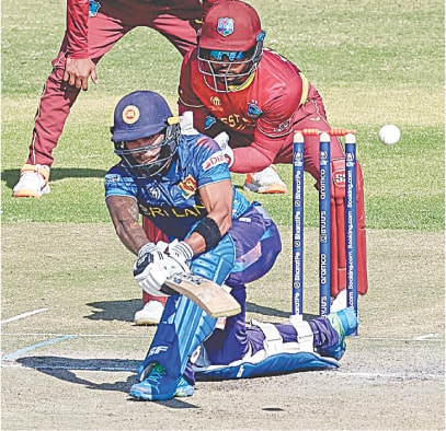  SRI LANKAN opener Pathum Nissanka plays a sweep shot as West Indies’ wicket-keeper Shai Hope watches during their Super Six match of the ICC World Cup qualifier at the Harare Sports Club on Friday.—AFP 