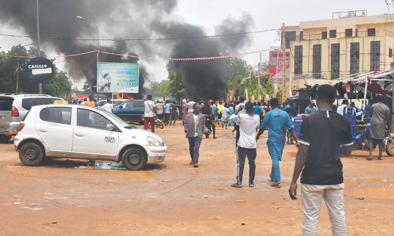 Smoke billows as supporters of Nigerien putschists attack the headquarters of the party of overthrown President Mohamed Bazoum in Niamey, on Thursday.&mdash;AFP
