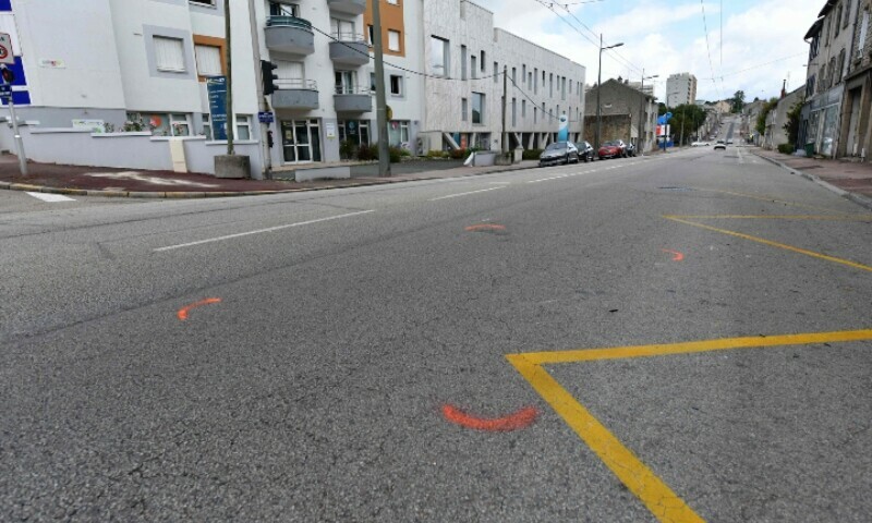 This photograph taken on August 6, 2023, shows orange painted traces in the foreground representing the location of the vehicle that hit a scooter, with white traces indicating where the scooter stopped in the background (L), during the night between August 5 and 6, 2023. &mdash; AFP