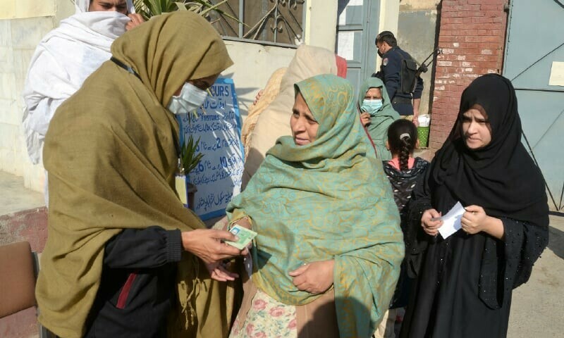 PESHAWAR: A security woman checks the identity card of a voter at a polling station. &mdash; Shahbaz Butt / White Star
