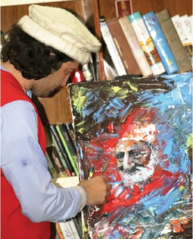 Imam Hussain Turab gives final touches to an art piece at his personal gallery. &mdash; Dawn