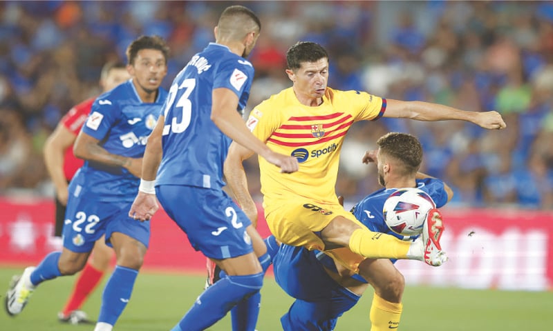 GETAFE: Barcelona’s Robert Lewandowski (C) vies with Getafe players Stefan Mitrovic (L) and Domingos Duarte during their La Liga match at Coliseum Alfonso Perez.—Reuters GETAFE: Barcelona’s Robert Lewandowski (C) vies with Getafe players Stefan Mitrovic (L) and Domingos Duarte during their La Liga match at Coliseum Alfonso Perez.—Reuters