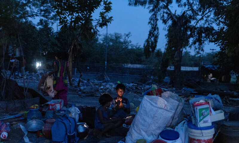 Ishant Kumar, 10, and Srishti Devi, 5, children of Dharmender Kumar who works as a clerk at Pragati Maidan which houses the main venue of G20 Summit, sit next to their belongings after their house was bulldozed during a demolition drive by the authorities at a slum area near the upcoming summit venue in New Delhi, India on June 1, 2023. — Reuters