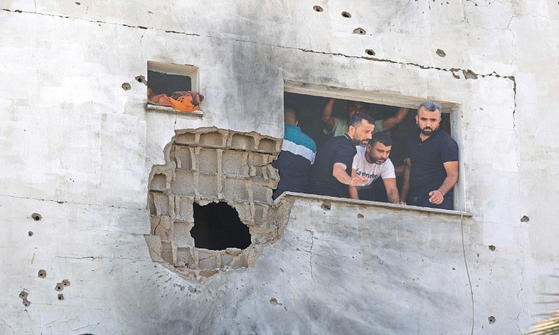 OCCUPIED WEST BANK: Palestinians inspect a damaged house following an Israeli military raid in the village of Al Aqaba, on Friday. One Palestinian was killed in the raid.—AFP OCCUPIED WEST BANK: Palestinians inspect a damaged house following an Israeli military raid in the village of Al Aqaba, on Friday. One Palestinian was killed in the raid.—AFP