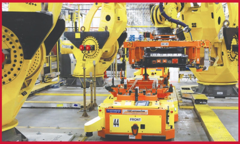 A robot lifts the battery as it is installed on the frame of Ford Motor Company battery-powered F-150 Lightning in Michigan. US industrial production kept expanding in August, the Federal Reserve said last week, beating expectations even though the increase slowed due to sluggish manufacturing growth.—AFP