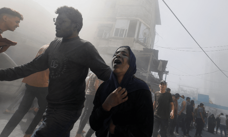 Palestinians flee at the site of Israeli strikes on houses in Khan Younis in the southern Gaza Strip on October 26. &mdash; Reuters