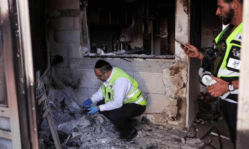  Members of the ZAKA search and rescue team search through a house that was raided during a deadly attack by Hamas gunmen from the Gaza Strip, in Kibbutz Holit in southern Israel, on October 26. &mdash; Reuters 