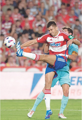 GRANADA: Raul Torrente (front) of Granada fights for the ball with Barcelona’s Sergi Roberto during their La Liga match at the Nuevo Estadio de Los Carmenes.—AFP