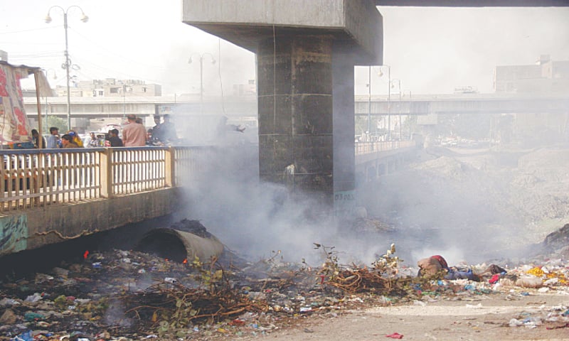 Smoke billows from a burning pile of garbage dumped along the Lyari river.&mdash;Online