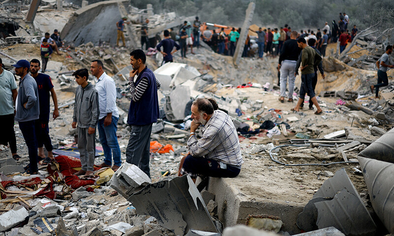 A man sits among rubble as Palestinians gather at the site of an Israeli strike, amid Israel&rsquo;s bombardment of Gaza, in Khan Younis in the southern Gaza Strip November 12, 2023.&mdash;Reuters
