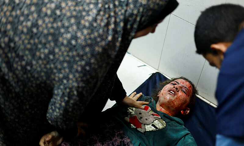 A Palestinian child lies on the floor in Nasser hospital following Israeli strikes, in Khan Younis in the southern Gaza Strip November 23, 2023.&mdash;Reuters