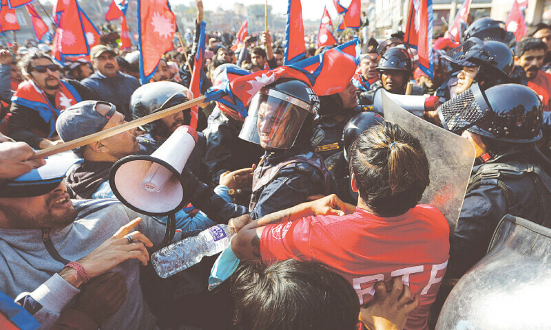 A POLICE official gets a hit on his helmet during the clash with pro-monarchy
protesters.&mdash;Reuters