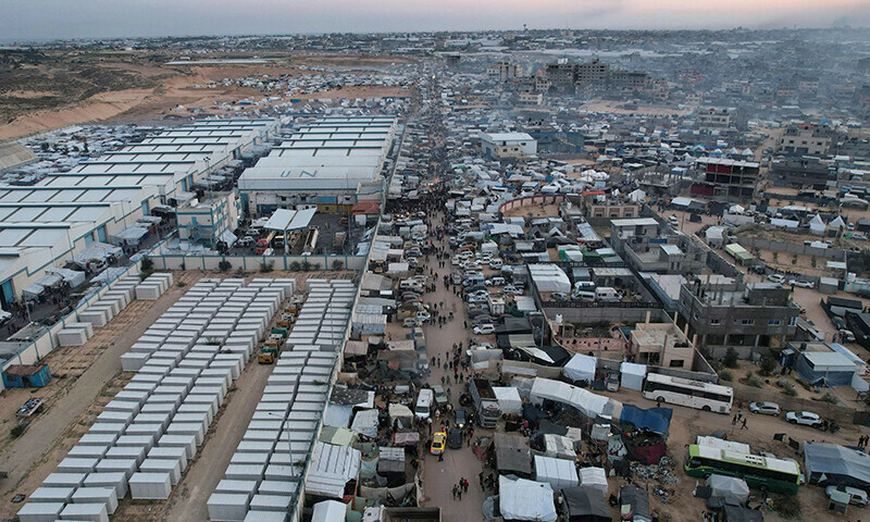 An aerial picture shows displaced Palestinians who fled Khan Yunis setting up camp near warehouses affiliated in the UN in Rafah further south near the Gaza Strip&rsquo;s border with Egypt, on December 7, 2023.&mdash;AFP