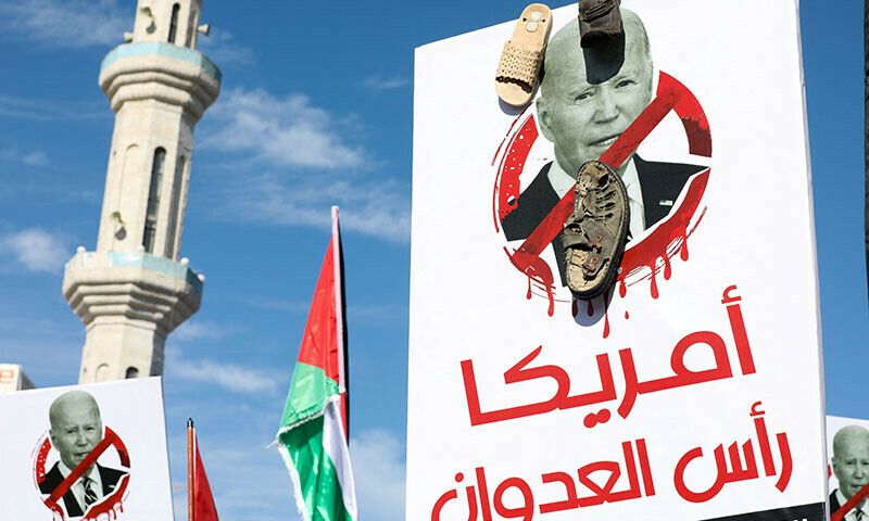 A person holds a placard with a crossed out picture of U.S. President Joe Biden and shoes attached to it during a protest in support of Palestinians in Gaza, in Amman, Jordan December 8, 2023. &mdash; Reuters