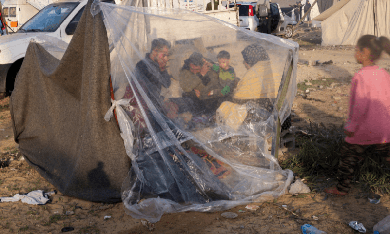 Displaced Palestinians, who fled their houses due to Israeli strikes, sit in their makeshift shelter at a tent camp in Rafah, in the southern Gaza Strip December 12. &mdash; Reuters
