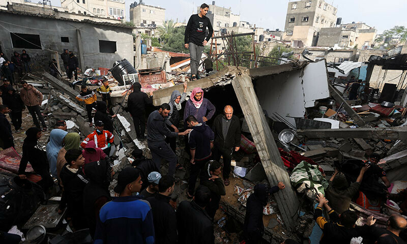 Palestinians inspect the damage at the site of Israeli strikes on houses in Khan Younis in the southern Gaza Strip, December 13, 2023. &mdash; Reuters