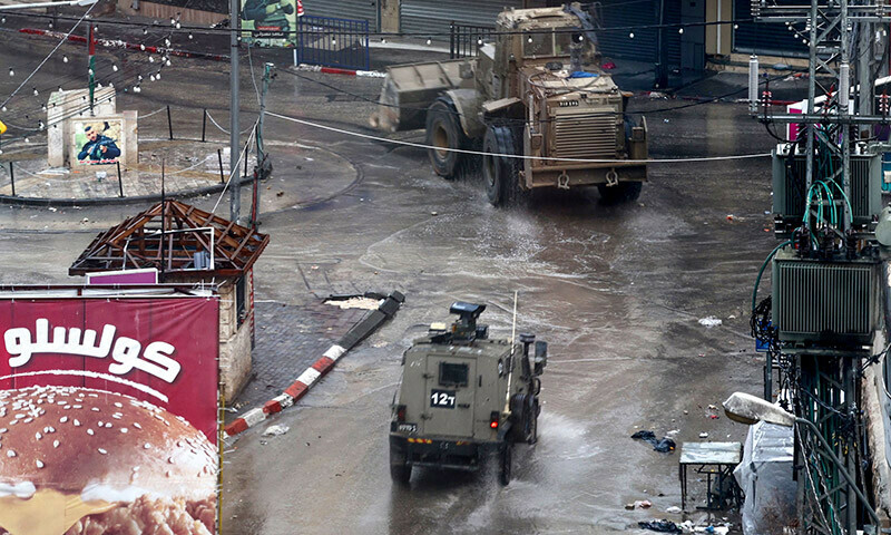 Israeli army vehicles drive through Jenin in the occupied West Bank, on December 13, 2023, following an overnight army raid in the city. &mdash; AFP)