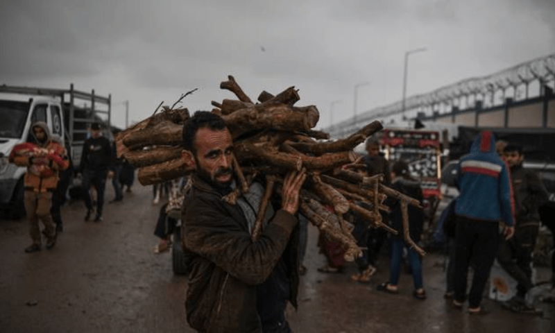 Palestinians are seen collecting wood to start fire amid cold weather in Gaza. &mdash; Anadolu Agency