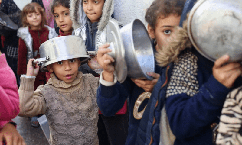 Palestinian children queue for food at a charity kitchen in Rafah, southern Gaza Strip. &mdash; Reuters