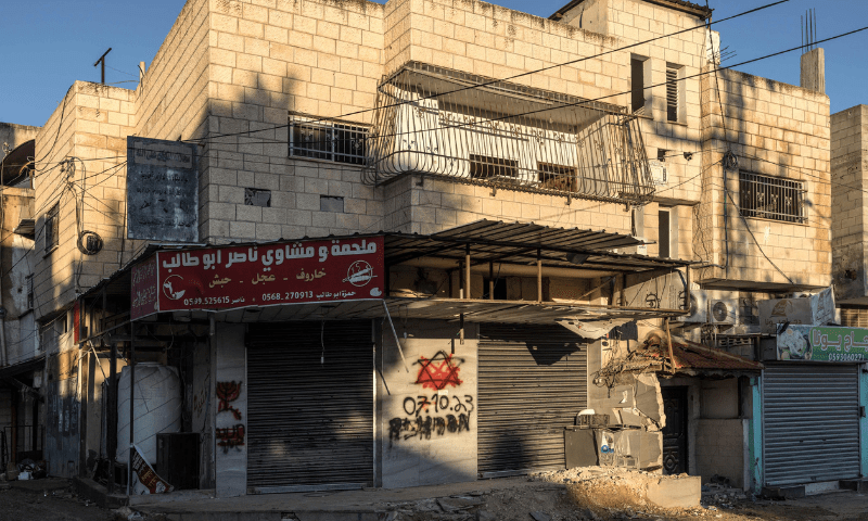 Red paint covers a Star of David with the date of October 7, 2023, sprayed by Israeli soldiers on a wall of a house in the Jenin refugee camp, on December 15, 2023. &mdash; AFP