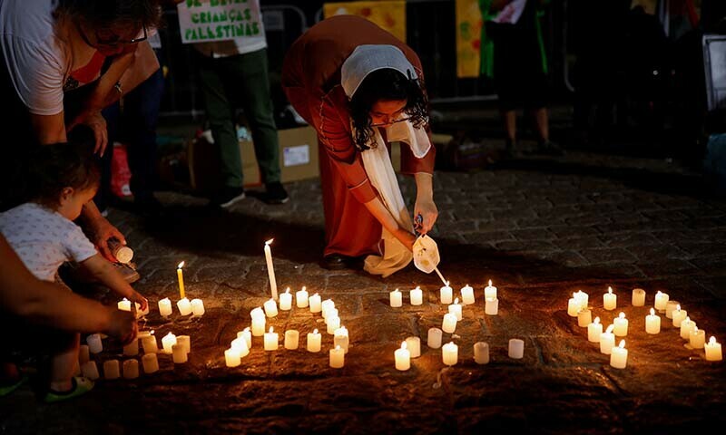 People light candles during a vigil in tribute to Palestinian children in Gaza in Brazil on December 15, 2023 &mdash; Reuters