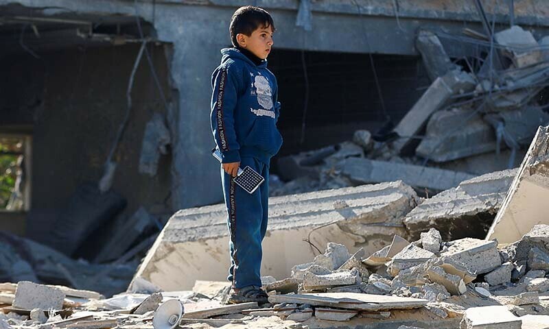 A Palestinian child looks on at the site of an Israeli strike on a house in Rafah, in the southern Gaza Strip on December 16, 2023 &mdash; Reuters