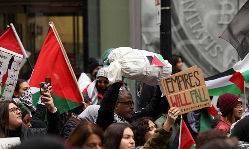 A demonstrator marches with a replica of a dead Palestinian child wrapped in a burial shroud at a rally held by the Boston Coalition for Palestine, calling for a permanent ceasefire in Gaza on December 17, 2023. &mdash; Reuters