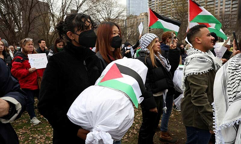 A demonstrator marches with a replica of a dead Palestinian child wrapped in a burial shroud at a rally held by the Boston Coalition for Palestine, calling for a permanent ceasefire in Gaza on December 17, 2023. &mdash; Reuters