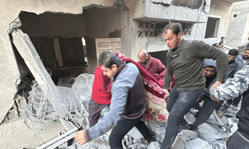 Civil defence teams and local residents carry dead bodies unearthed from the rubble following Israeli attacks on Jabalia camp. &mdash; Anadolu Agency
