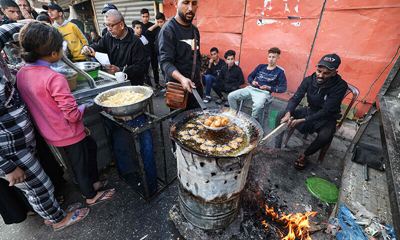 Palestinians cook falafel in Rafah in the southern Gaza Strip on December 18, 2023. &mdash; AFP