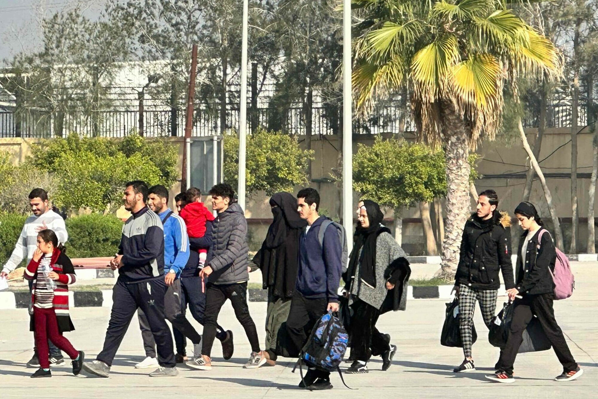 Travellers crossing from the Gaza Strip enter the Egyptian side of the Rafah border crossing with the Palestinian enclave following their evacuation on December 18. &mdash; AFP