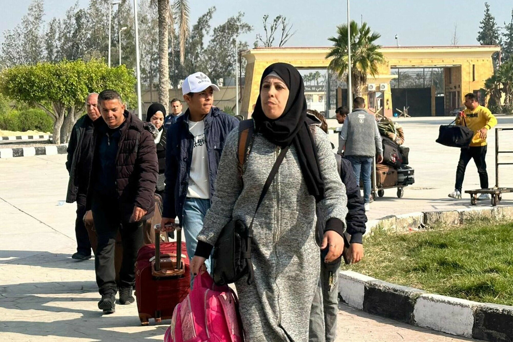 Travellers crossing from the Gaza Strip enter the Egyptian side of the Rafah border crossing with the Palestinian enclave following their evacuation on December 18. &mdash; AFP