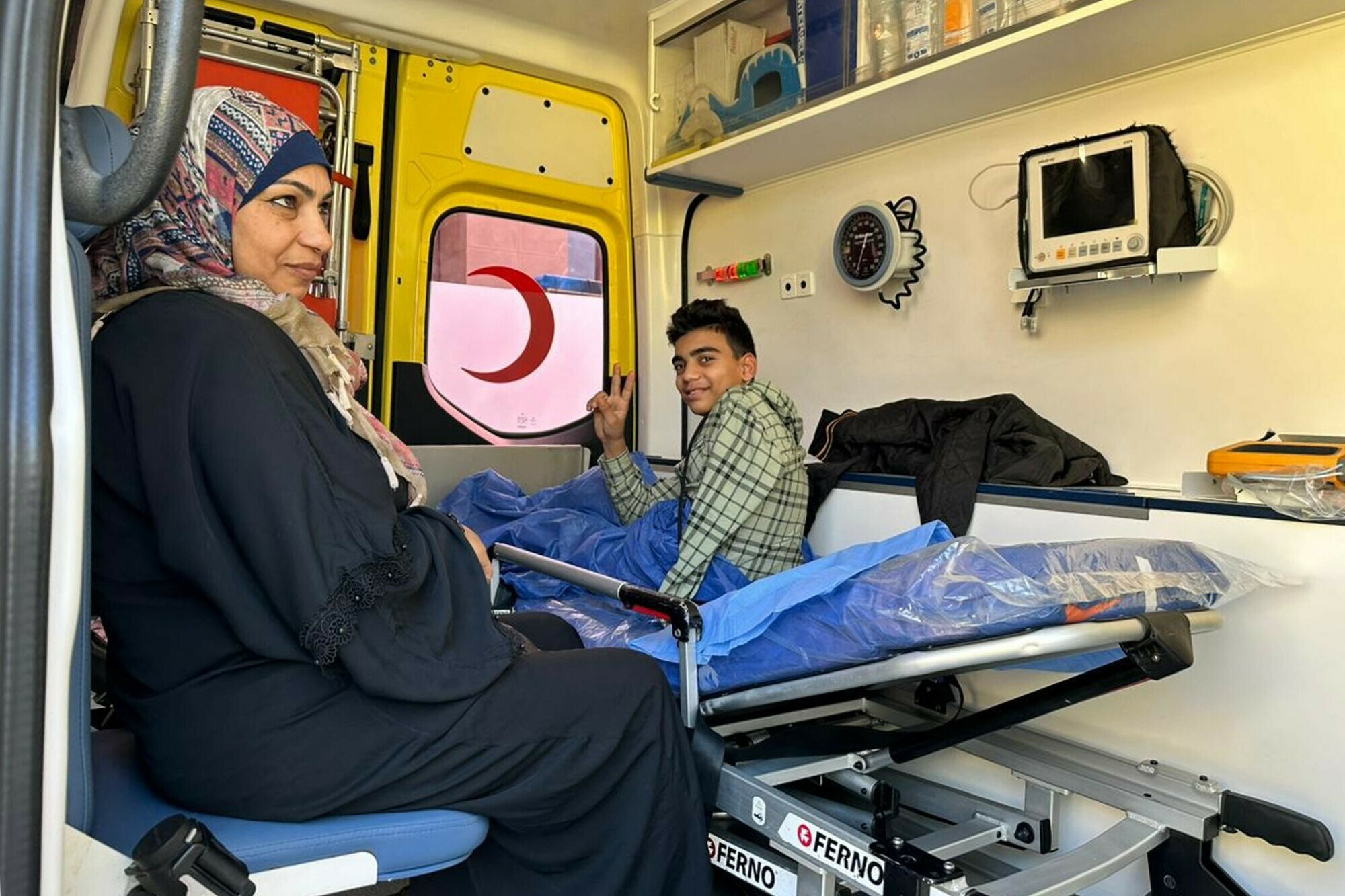 A Palestinian youth lying in an ambulance for treatment gestures as he lies on a gurney after crossing from the Gaza Strip to enter the Egyptian side of the Rafah border crossing with the Palestinian enclave following evacuation on December 18. &mdash; AFP