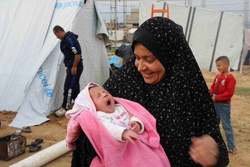 Mervat Salha, the grandmother of Palestinian baby girl Mariam who was born during the fighting between Israel and Hamas, holds her outside a tent where they shelter with their displaced family who fled their house due to Israeli strikes, in Rafah in the southern Gaza Strip, December 17. &mdash; Reuters