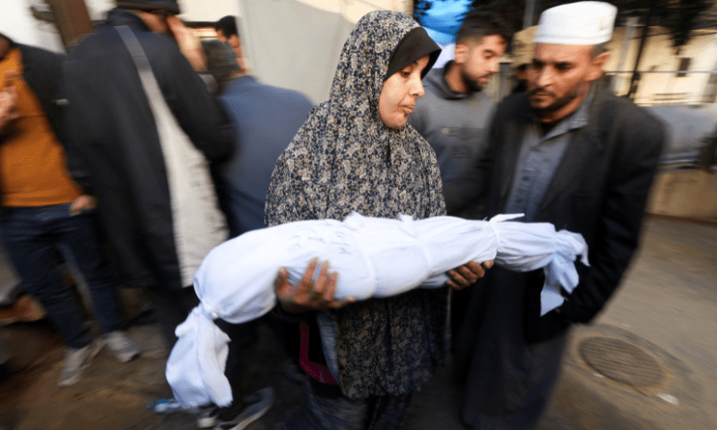 Suzan Zourob, the grandmother of two Palestinian children who were killed in an Israeli strike, holds a child&rsquo;s body, in Rafah, in the southern Gaza Strip, December 19. &mdash; Reuters