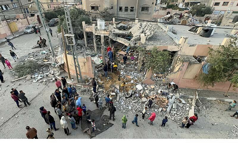 Palestinians gather at the site of an Israeli strike on a house in Khan Younis in the southern Gaza Strip on December 20, 2023. &mdash; Reuters