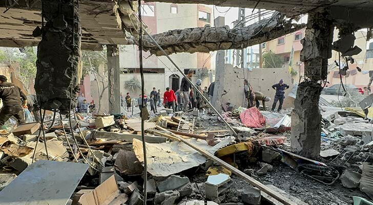  Palestinians gather at the site of an Israeli strike on a house in Khan Younis in the southern Gaza Strip on December 20, 2023. &mdash; Reuters 