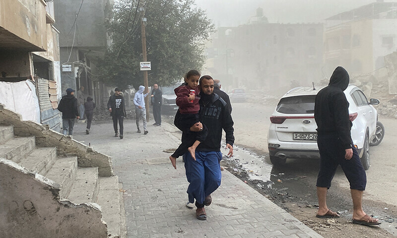 A Palestinian man carries a child, in the aftermath of an Israeli strike, amid the ongoing Israeli bombardment in Rafah, in the southern Gaza Strip, December 20, 2023.&mdash;Reuters