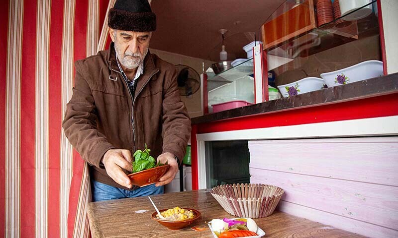 Lebanese Hussein Murtada prepares food in his restaurant in the village of Kfar Kila near the border with Israel. In Kfar Kila, nestled among olive trees, some houses have been completely destroyed, and the sound of nearby bombardment rumbles through the air. Just one grocery store is still open in Murtada&rsquo;s area, and streets are largely deserted after many villagers fled &mdash; AFP